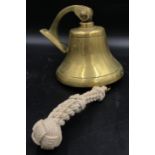 A large unmarked ships bell with wall attachment with woven rope still attached approx 18cm h