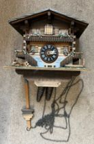 A vintage Swiss made wooden cuckoo clock with metal weights. 20cm h.