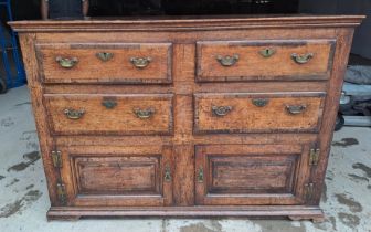 A Georgian oak dresser base with cross banding to drawers and brass handles. 135cm w 52cms d x