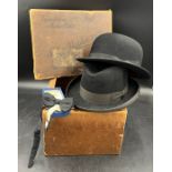 Vintage bowler and trilby hats and a bow tie all contained within an original cardboard hat box.