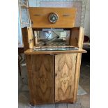 A walnut Art Deco cocktail cabinet with a fall front and pop up section top, housing a mirrored