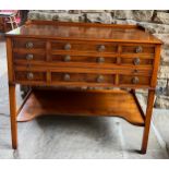 A yew wood reproduction cabinet with 7 drawers and pull out slide. Top 3 drawers containing 12 place
