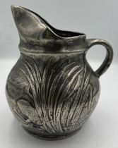 A pewter jug with frogs in reeds. 15cm h.