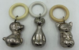 Three contemporary silver plated baby rattles with teething rings, a dog, a cat and a koala bear.