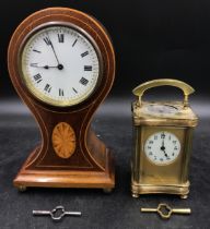 A mahogany inlayed balloon mantle clock on brass ball feet with circular white dial with roman