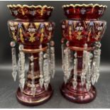 A pair of 19thC ruby glass table lustres with painted floral and gilded decoration standing approx