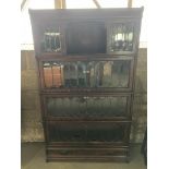 A dark oak 4 height globe Wernicke and co ltd bookcase with leaded glass fronts and drawer to base