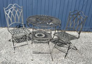 A silvered cast steel garden table and two chairs. Table 75cm h x 68cm diameter.