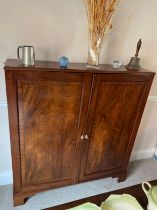 A two door mahogany cupboard on later bracket feet 129cm h x 120cm w x 27cm d