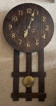 An oak Arts and Crafts wall clock with brass pendulum and 80cm h. Brass hands and numbers.