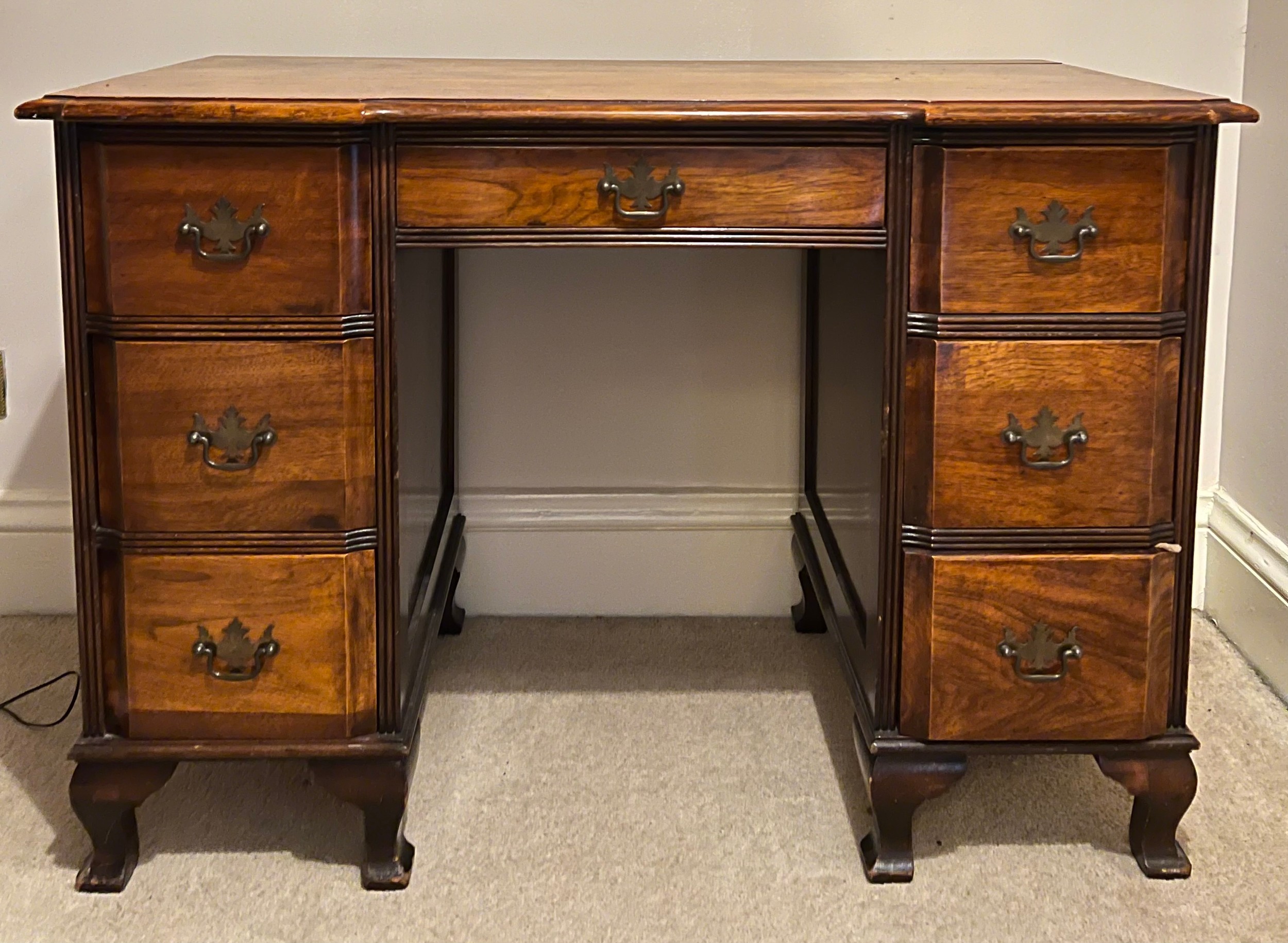 An early 20thC mahogany kneehole desk on bracket feet 73cm h x 106cm w x 53cm d.