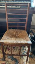 An Arts and Crafts fruitwood single chair with rush seat. 84cm h to back.