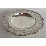 A hallmarked silver dish raised on three feet with pierced foliate border. Sheffield 1932, maker