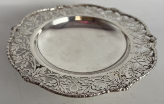 A hallmarked silver dish raised on three feet with pierced foliate border. Sheffield 1932, maker