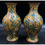 A pair of Victorian Doulton vases decorated in white flowers and leaves signed to the base LC and