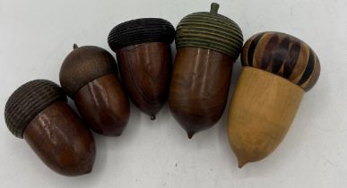 Five wooden (treen) acorn thimble holders and thimbles. Three hallmarked silver thimbles including