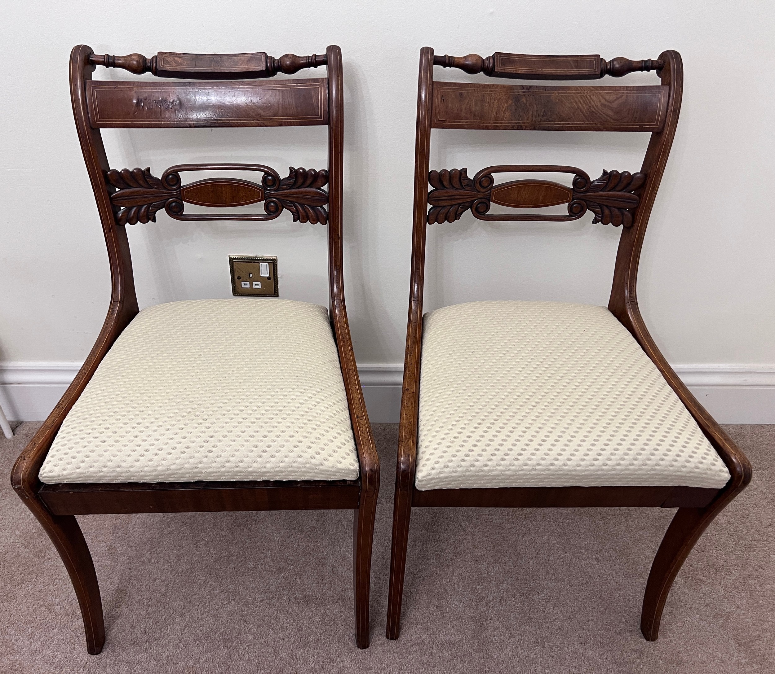 A pair of regency mahogany sabre legged dining chairs.