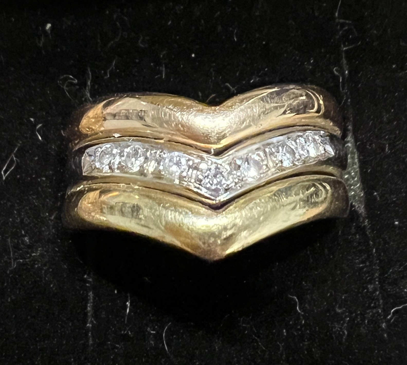 A 18 carat white and yellow gold ring set with a v shaped band of diamonds. Weight 5.3gm. Size M.