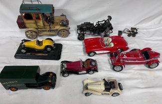 A collection of model cars to include 4 x Burago models, a Franklin Mint, 2 metal vehicle sculptures