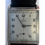 A vintage Rolex Tudor hand winding wristwatch on black leather strap, chrome case and ivory dial