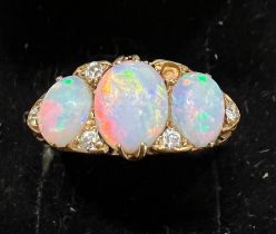 A 19thC 18 carat gold ring set with opals and diamonds. Size L. Weight 4.5gm.