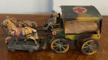 A WW1 tin plate ambulance pulled by two horses on a wooden base with a soldier plus an