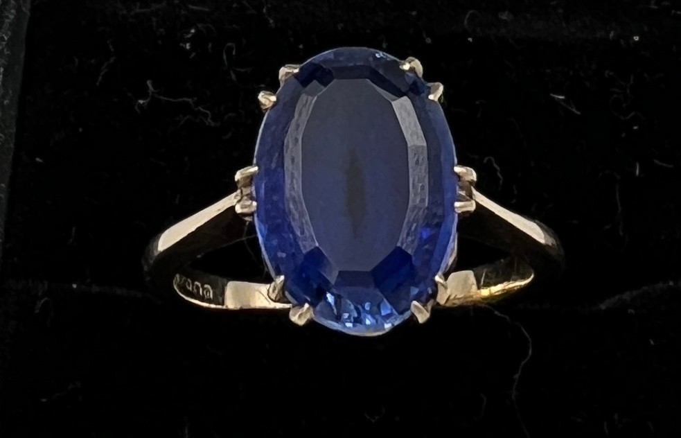 A 9 carat golds ring set with blue stone. Size N, weight 4gm.