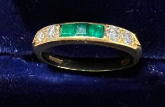 An 18 carat gold ring set with diamonds and emeralds. Size L. Weight 2.6gm.