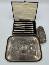 A silver floral embossed tray 25.5 x 19cm London 1984, makers mark rubbed, together with a boxed set