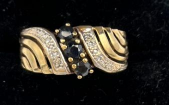 A 9 carat gold ring set with sapphire and diamonds. Size K. Weight 1.9gm.