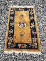 A mustard ground oriental style rug with central medallion. 94 x 152cm.