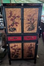 A Chinese painted and lacquer cabinet with two opening doors over two drawers, over two cupboards.