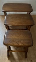 A nest of three Ercol tables. Largest 57cm x 35cm x 41cm h.