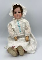 An Armand Marseille bisque headed doll marked 390 A.11.M. with weighted brown sleeping eyes, open