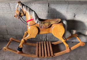 Large vintage wooden rocking horse with horse hair mane and tail, leather bridle and saddle.