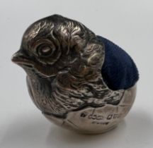 A silver pincushion formed as a hatching chick, Chester 1907, maker Sampson Mordan. 4cm h.