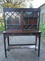 Oriental style mahogany carved display cabinet with two shelves to interior and two shallow drawers.