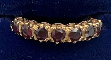 A nine carat gold ring set with seven garnets. Size P. Weight 2.7gm.
