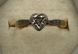 An 18 carat and platinum heart shaped ring set with diamond chip. Size J/K. Weight 1.9gm.