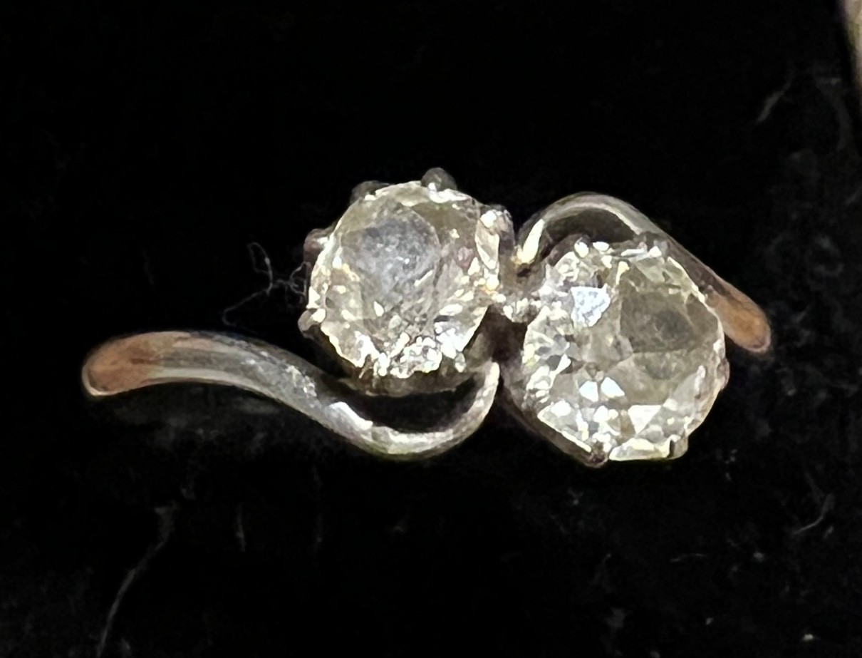 A platinum ring set with two diamonds in a crossover setting. Size P. Weight 3.6gm.