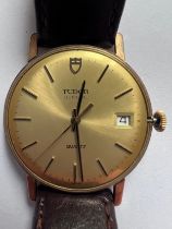 A gentleman's Tudor Geneve quartz 9ct gold wristwatch on brown leather strap with date aperture,