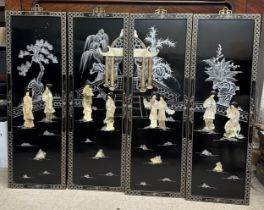 A set of four 20thC shibyama type wall panels depicting figures in a garden setting in front of a