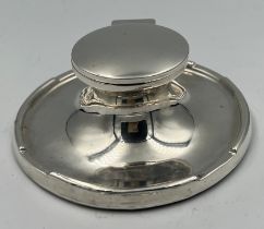 A weighted silver capstan inkwell with glass liner Birmingham 1912, maker A & J Zimmerman Ltd.