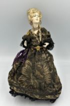 A 19thC doll with bisque head and arms on a weighted base. 32cm h.