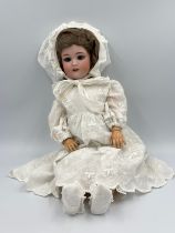 A German porcelain head doll by Simon & Halbig. Marked S & H 10 with blue sleeping eyes, light brown