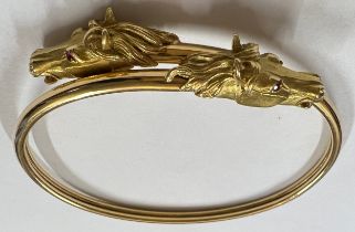 A 18 carat gold horse head bangle with ruby eyes. Weight 22.7gm.