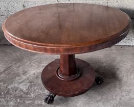 A 19thC circular mahogany tilt top table on central pedestal and claw feet.