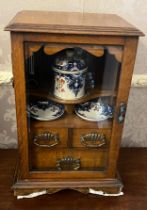 An Edwardian oak smokers cabinet with three internal drawers, tobacco jar, plates and pipe. 27cm w x