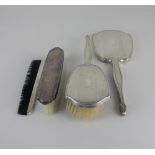 A Queen Elizabeth II silver four piece dressing table set of hand mirror, two brushes and a comb (