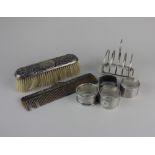 A George V silver toast rack Birmingham 1930 four various silver napkin rings, silver backed